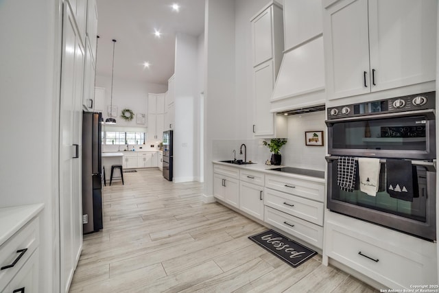 kitchen featuring white cabinetry, double wall oven, black electric cooktop, and custom exhaust hood