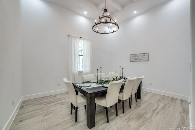 dining area with coffered ceiling, a notable chandelier, beam ceiling, and light hardwood / wood-style floors