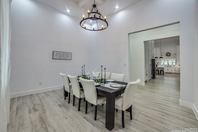 dining area with an inviting chandelier, beam ceiling, and light wood-type flooring