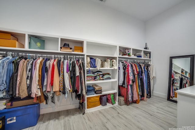 walk in closet with light wood-type flooring