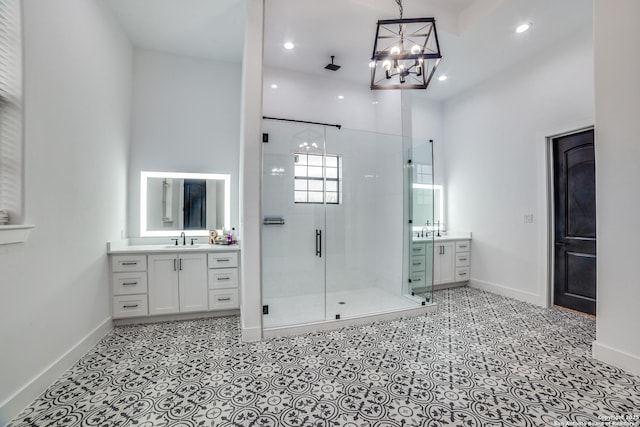 bathroom with a towering ceiling, vanity, a chandelier, and a shower with door