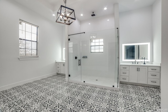 bathroom with vanity, a shower with shower door, and a healthy amount of sunlight