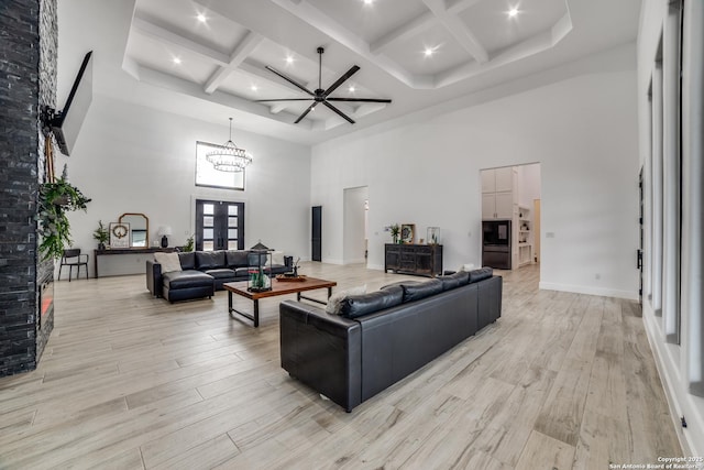 living room with coffered ceiling, a towering ceiling, beam ceiling, and french doors