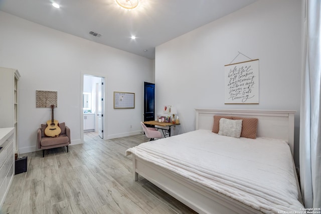 bedroom featuring connected bathroom and light wood-type flooring