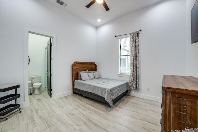 bedroom with ceiling fan, ensuite bath, and light hardwood / wood-style flooring