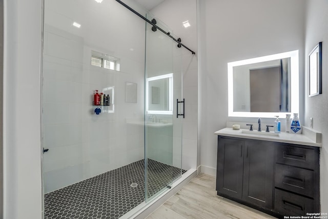 bathroom with hardwood / wood-style flooring, vanity, and a shower with shower door