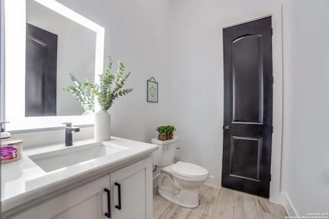 bathroom featuring hardwood / wood-style flooring, vanity, and toilet