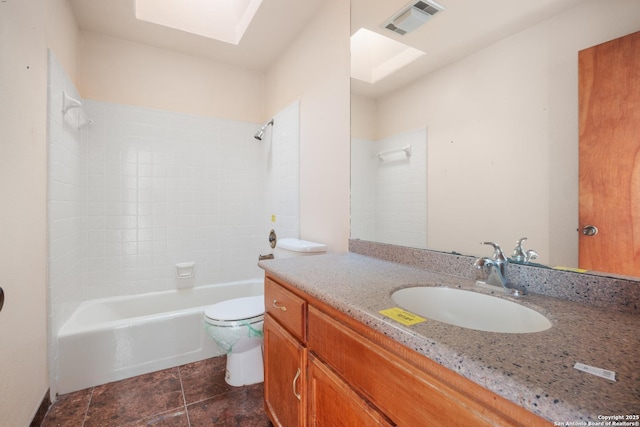 full bathroom featuring vanity, tiled shower / bath combo, a skylight, and toilet