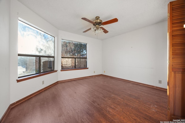 spare room with dark hardwood / wood-style floors, a textured ceiling, and ceiling fan