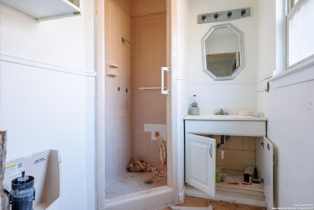 bathroom featuring tiled shower and vanity