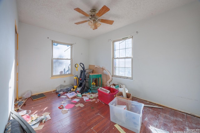 playroom featuring ceiling fan, dark hardwood / wood-style flooring, and a textured ceiling