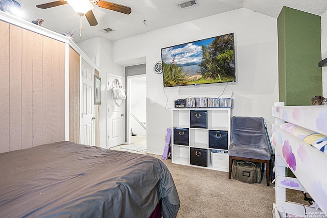 carpeted bedroom with ceiling fan and a textured ceiling