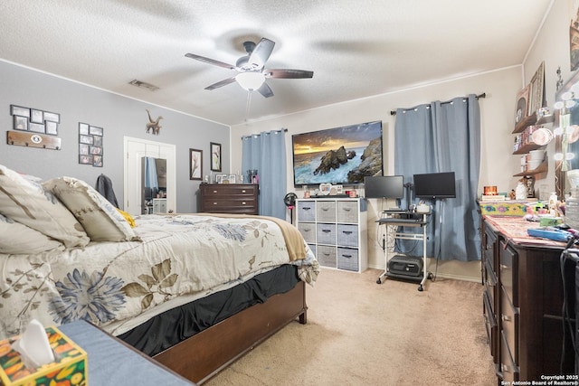 carpeted bedroom with ceiling fan and a textured ceiling