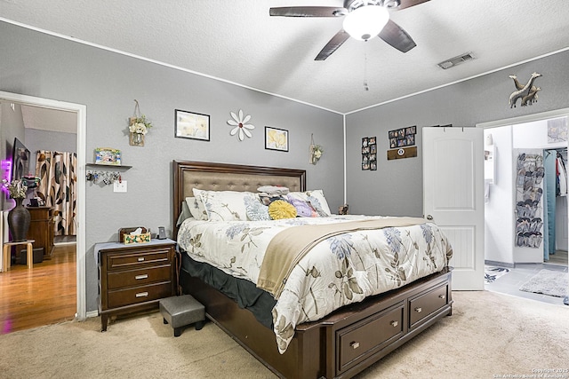 carpeted bedroom featuring a textured ceiling and ceiling fan