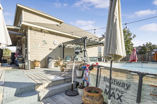 wooden terrace featuring a swimming pool and a pergola