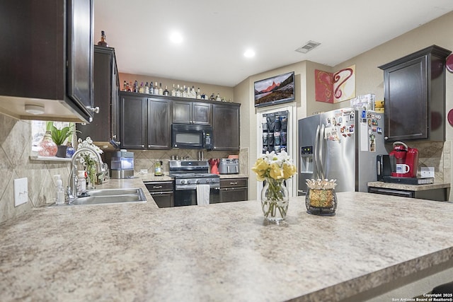 kitchen with dark brown cabinetry, stainless steel appliances, sink, and backsplash