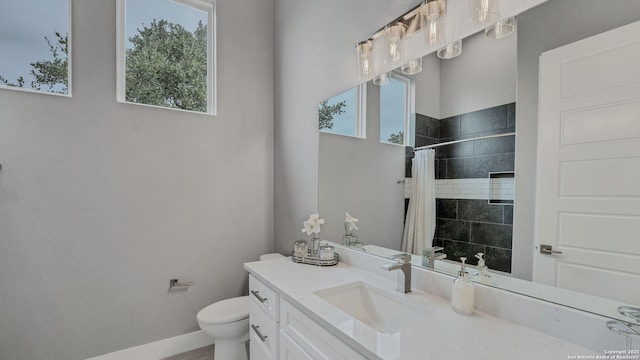 bathroom with walk in shower, vanity, and toilet