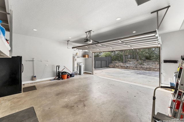 garage featuring black refrigerator, a garage door opener, and water heater