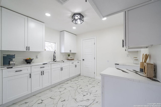 kitchen featuring white cabinetry and sink