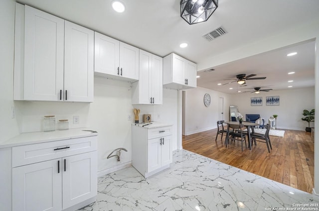 kitchen featuring white cabinets and ceiling fan