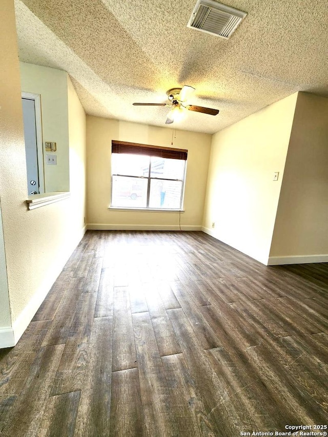 spare room featuring ceiling fan, dark hardwood / wood-style floors, and a textured ceiling