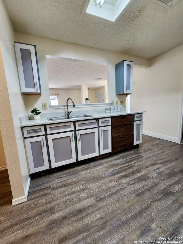 kitchen with dark hardwood / wood-style flooring, sink, and a textured ceiling