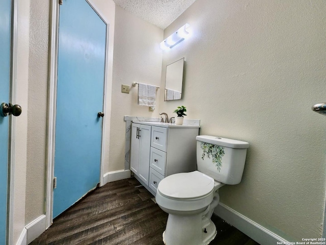 bathroom featuring vanity, hardwood / wood-style floors, a textured ceiling, and toilet