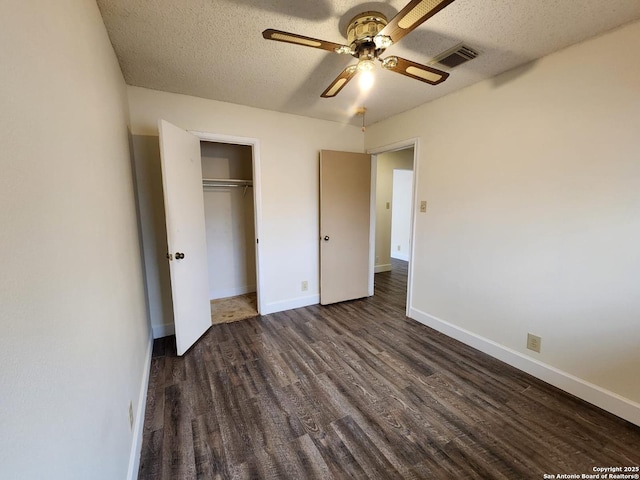 unfurnished bedroom featuring dark hardwood / wood-style flooring, a textured ceiling, a closet, and ceiling fan