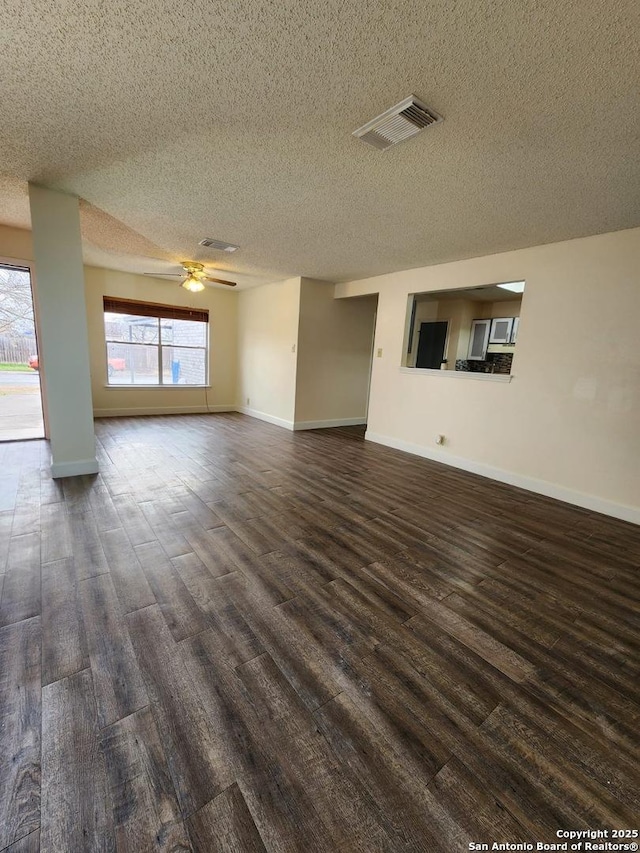 unfurnished living room with ceiling fan, dark hardwood / wood-style floors, and a textured ceiling