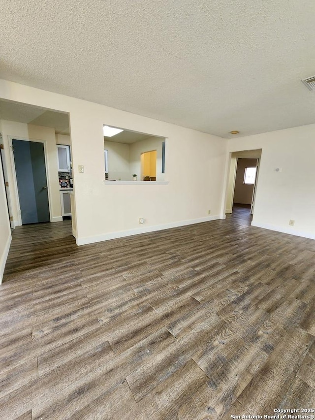 unfurnished living room with hardwood / wood-style flooring and a textured ceiling