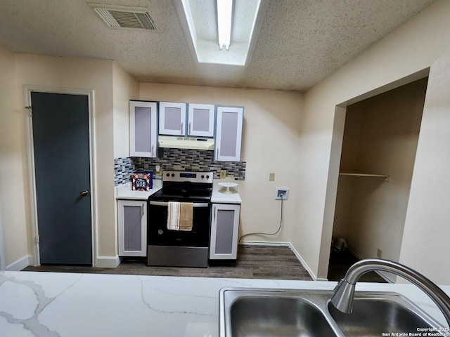 kitchen featuring gray cabinets, sink, decorative backsplash, a textured ceiling, and electric stove