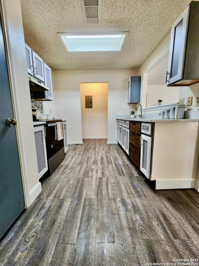 kitchen with dark hardwood / wood-style flooring, gray cabinetry, a textured ceiling, and stainless steel electric range