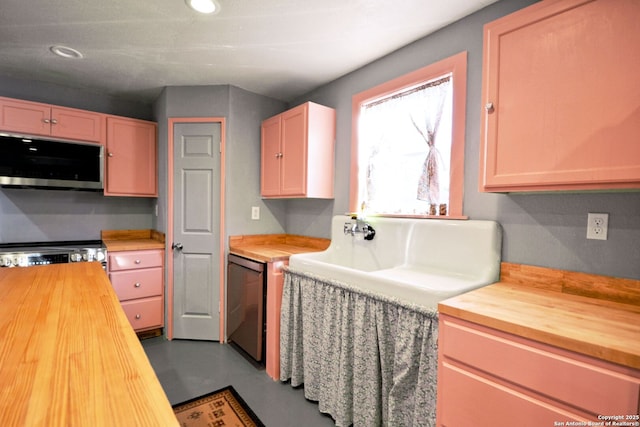 kitchen with concrete flooring, wooden counters, light brown cabinets, black dishwasher, and stove