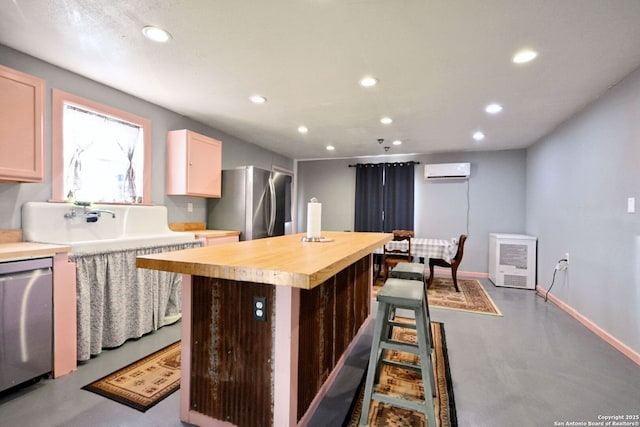 kitchen featuring stainless steel appliances, a center island, concrete floors, and a wall unit AC