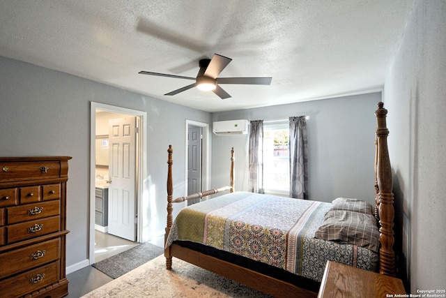 bedroom with ceiling fan, a wall mounted air conditioner, ensuite bathroom, and a textured ceiling