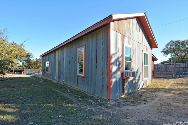 view of side of property featuring cooling unit and a lawn