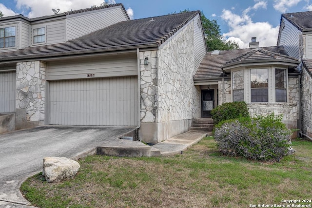 view of side of property with a garage and a lawn