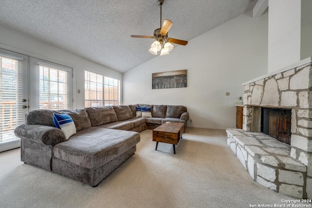 living room with lofted ceiling, a stone fireplace, light carpet, a textured ceiling, and a wealth of natural light