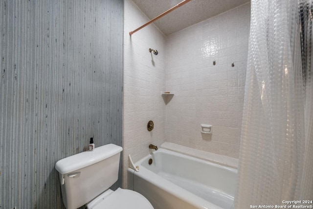 bathroom featuring shower / bathtub combination with curtain, a textured ceiling, and toilet