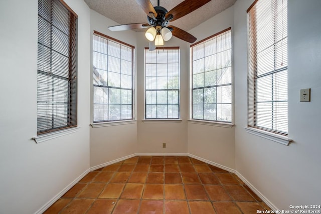 tiled spare room with ceiling fan, a healthy amount of sunlight, and a textured ceiling