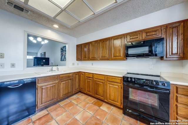 kitchen with sink, black appliances, a textured ceiling, and light tile patterned flooring