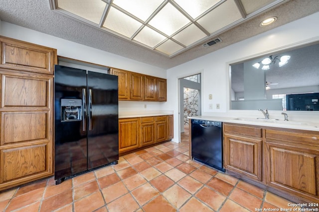 kitchen with sink, light tile patterned floors, ceiling fan, black appliances, and a textured ceiling