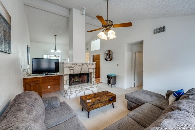 living room with a stone fireplace, high vaulted ceiling, light colored carpet, ceiling fan, and a textured ceiling