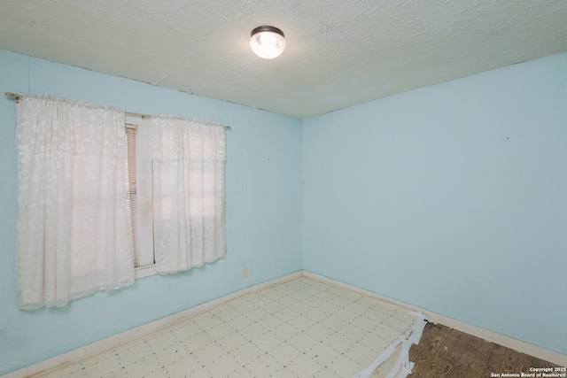 spare room with hardwood / wood-style flooring and a textured ceiling