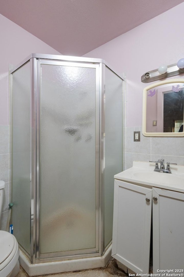 bathroom featuring vanity, tile walls, an enclosed shower, and toilet