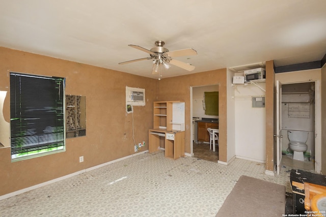 unfurnished bedroom featuring a closet, ensuite bath, a wall mounted AC, and ceiling fan