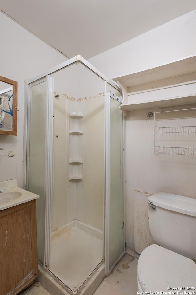 bathroom featuring vanity, toilet, and a shower with shower door