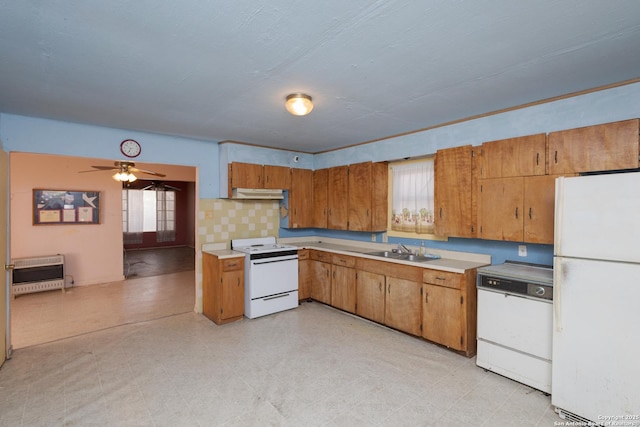 kitchen featuring sink, heating unit, plenty of natural light, white appliances, and decorative backsplash