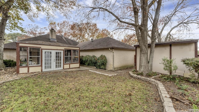 rear view of property featuring a yard and french doors