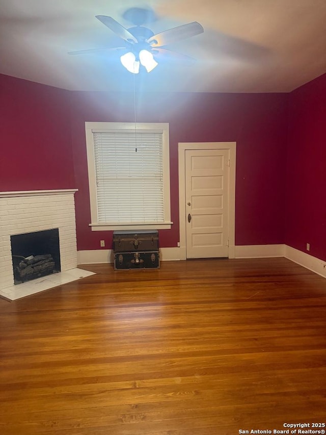 unfurnished living room with hardwood / wood-style flooring, ceiling fan, and a fireplace